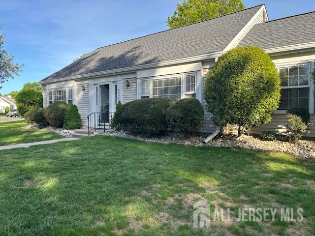 view of front of home featuring a shingled roof and a front yard