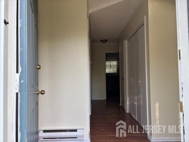 hallway with baseboard heating and wood finished floors