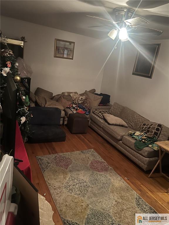 living room with ceiling fan and wood finished floors