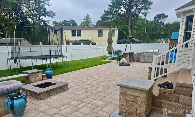 1485 Earie Way, Lacey, NJ 08731 - fenced backyard featuring a trampoline, a fire pit, a patio area, and area for grilling