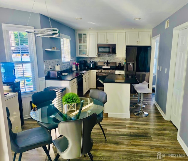 1485 Earie Way, Lacey, NJ 08731 - kitchen with stainless steel appliances, dark countertops, dark wood finished floors, a kitchen island, and decorative backsplash