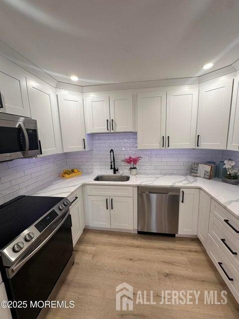 kitchen featuring sink, white cabinets, and appliances with stainless steel finishes