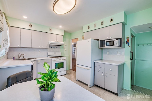 202 Garden Dr, South Plainfield, NJ 07080 - kitchen with white appliances, under cabinet range hood, a sink, decorative backsplash, and light countertops