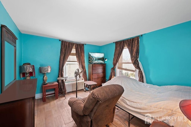 bedroom featuring light hardwood / wood-style floors and radiator heating unit