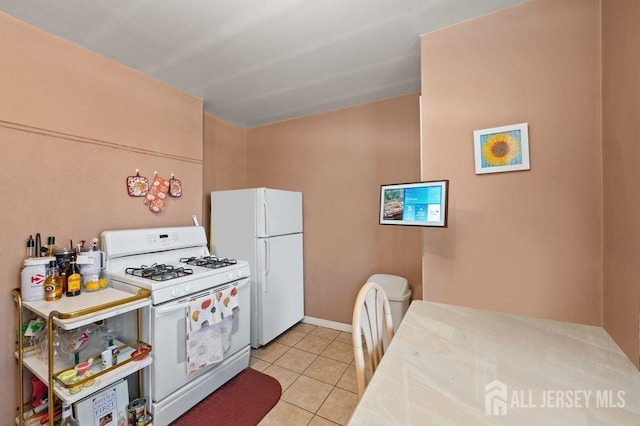 kitchen with light tile patterned floors and white appliances