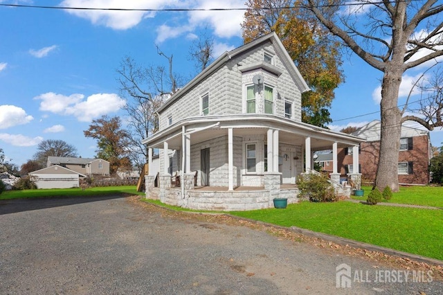 victorian home with a front yard and a porch