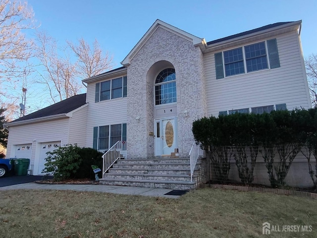 view of front of house with a garage and a front lawn