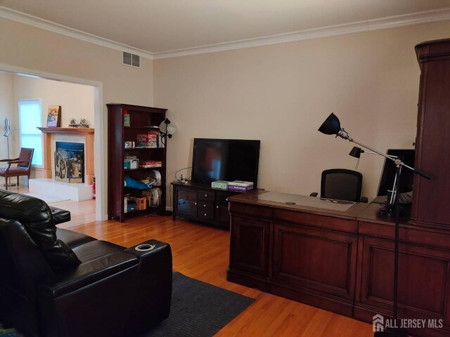 living room with crown molding and light hardwood / wood-style floors