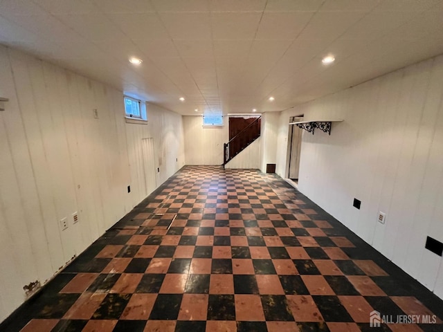 basement featuring wood walls