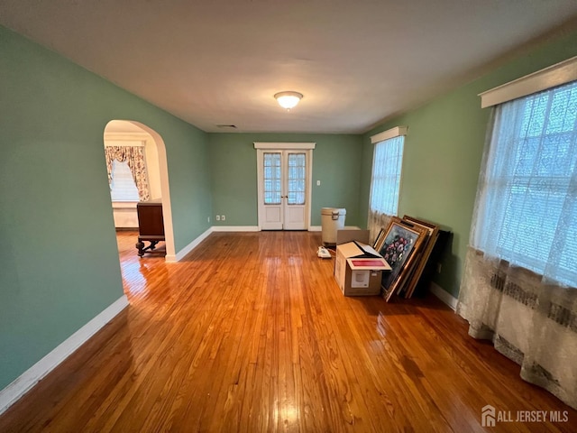 living area with hardwood / wood-style flooring and french doors