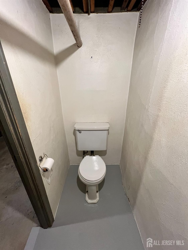 bathroom with concrete flooring and toilet