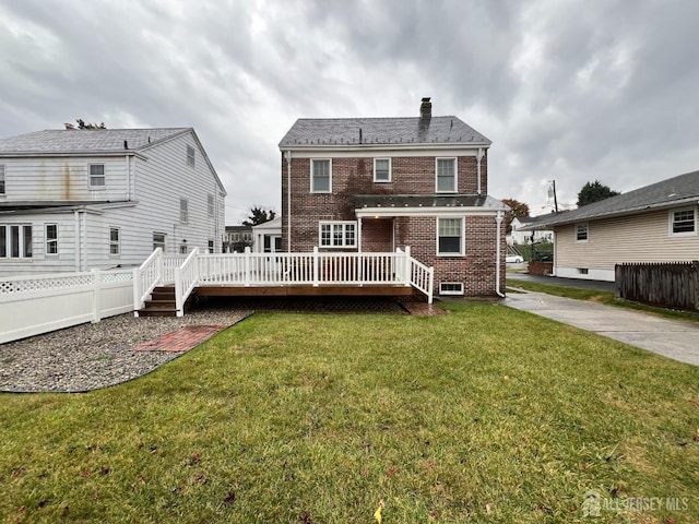 back of house featuring a deck and a lawn