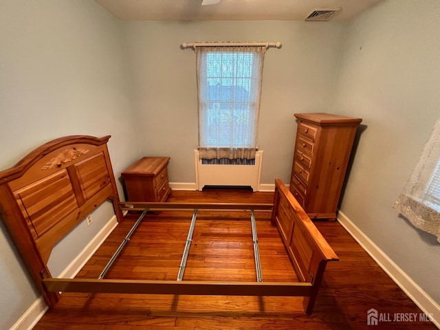 bedroom featuring radiator and dark hardwood / wood-style floors