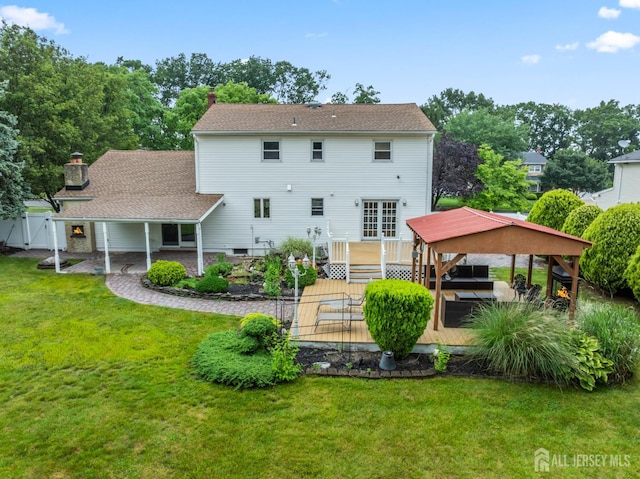 16 London Dr, East Brunswick, NJ 08816 - rear view of property featuring a wooden deck, a patio area, and a chimney