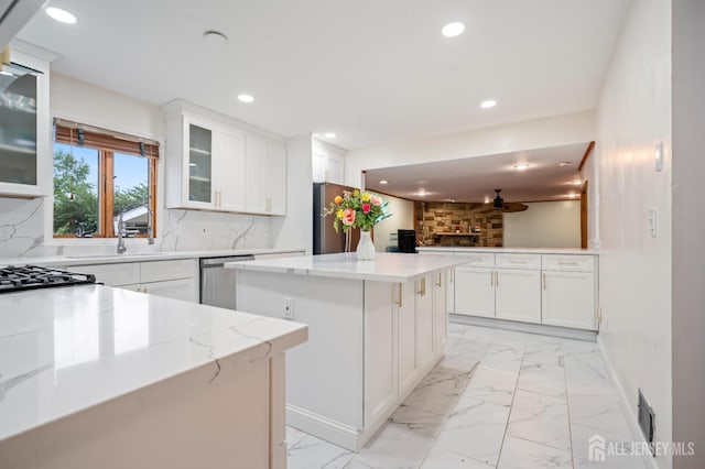 16 London Dr, East Brunswick, NJ 08816 - kitchen with stainless steel appliances, a kitchen island, recessed lighting, light marble finish flooring, and backsplash