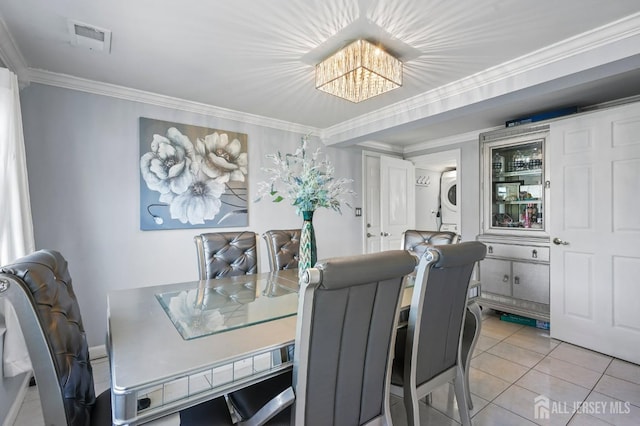 26 Venus Rd, Old Bridge, NJ 08879 - dining space featuring stacked washer / dryer, a chandelier, light tile patterned floors, and crown molding