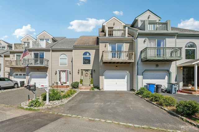 townhome / multi-family property with an attached garage, driveway, and a balcony