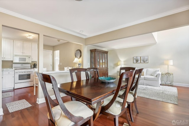 dining space featuring dark wood-style floors, baseboards, and crown molding
