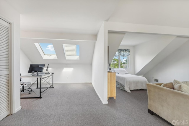 bedroom featuring a skylight, carpet floors, vaulted ceiling, a desk, and baseboards