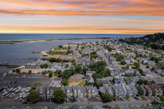 aerial view at dusk with a residential view and a water view