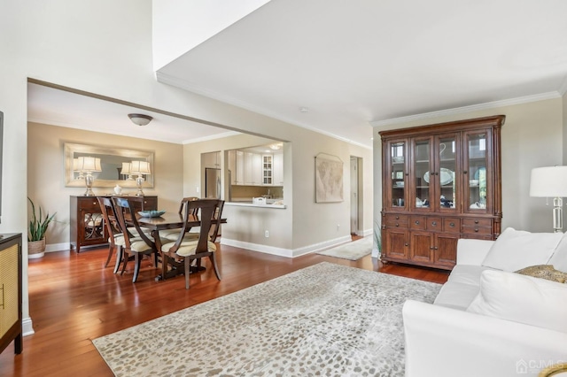 living room with dark wood-style flooring, crown molding, and baseboards