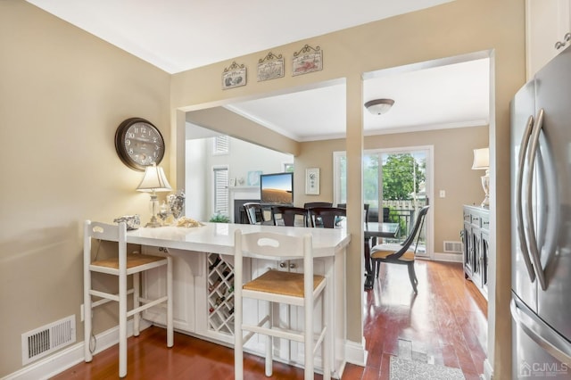 dining space featuring ornamental molding, wood finished floors, and baseboards