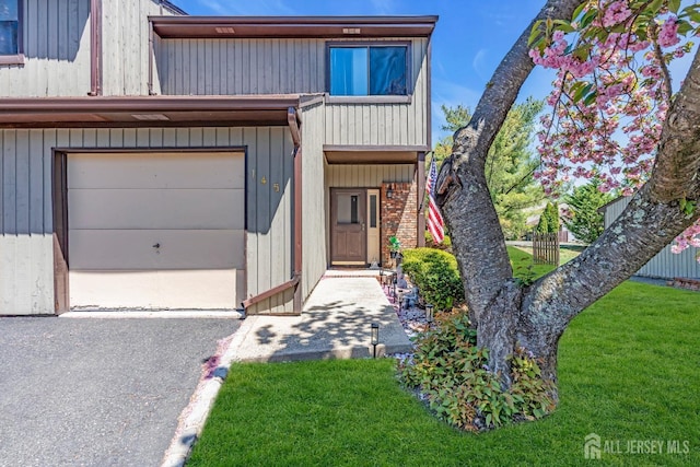 townhome / multi-family property with a garage and a front lawn