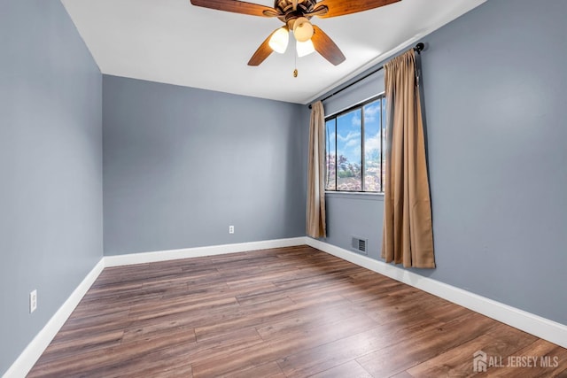 unfurnished room with a ceiling fan, baseboards, visible vents, and wood finished floors