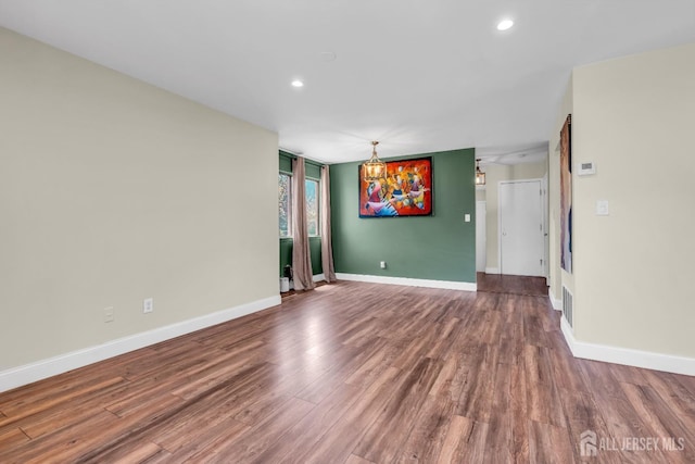 unfurnished room with baseboards, recessed lighting, and wood finished floors