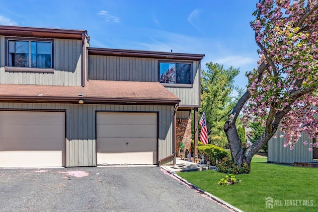 multi unit property featuring a front yard and aphalt driveway