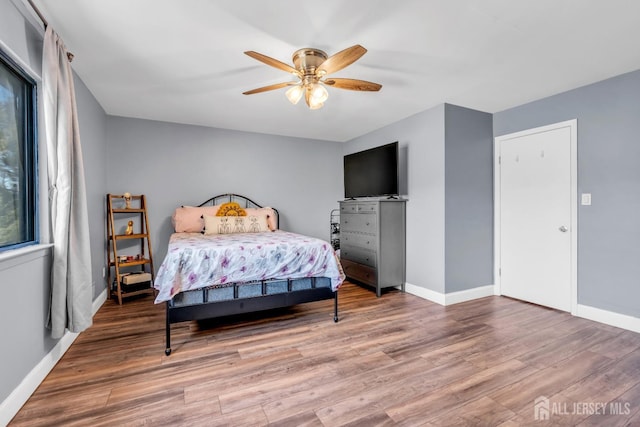 bedroom featuring baseboards, ceiling fan, and wood finished floors