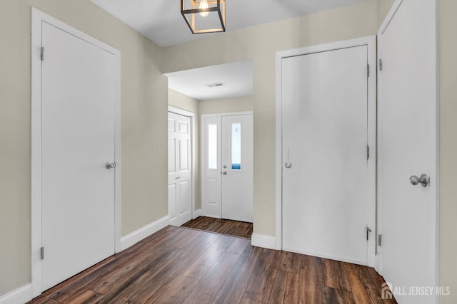 entrance foyer with baseboards, hardwood / wood-style flooring, and visible vents
