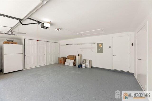 garage with electric panel, a garage door opener, and freestanding refrigerator