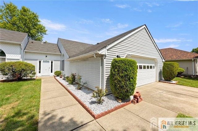 view of property exterior featuring concrete driveway, roof with shingles, a yard, and a garage
