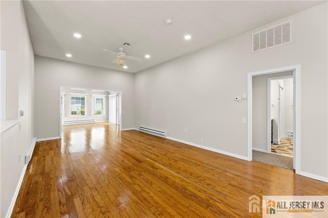 unfurnished living room with visible vents, hardwood / wood-style flooring, a baseboard radiator, baseboard heating, and recessed lighting