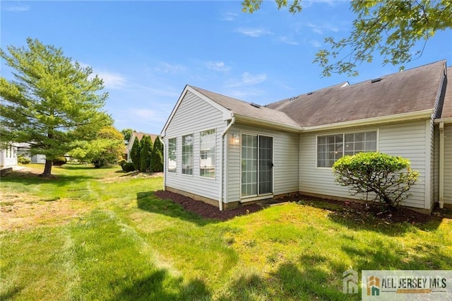 view of side of home with a lawn