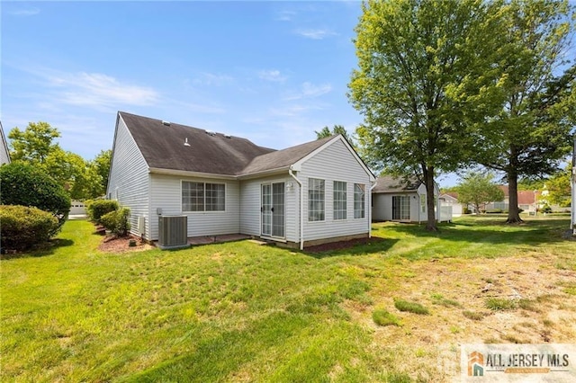 rear view of property featuring cooling unit and a yard