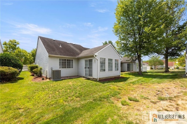 back of property with a lawn and central AC