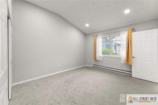 unfurnished bedroom featuring recessed lighting, vaulted ceiling, a baseboard heating unit, a textured ceiling, and carpet flooring