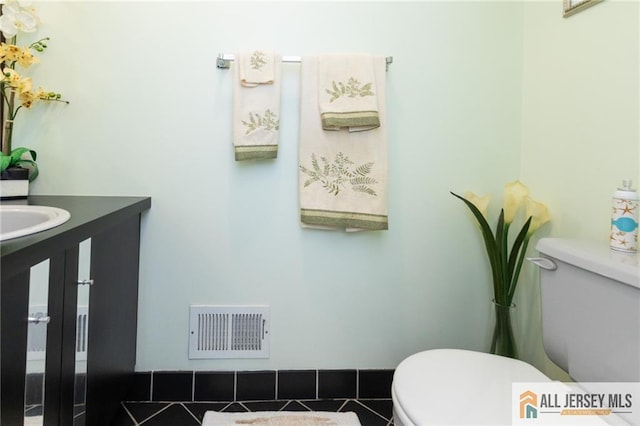 bathroom featuring tile patterned floors, vanity, and toilet