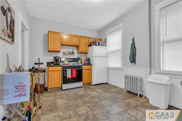 kitchen with white appliances, radiator heating unit, and light tile floors