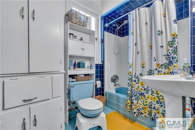 bathroom with toilet, tile floors, and shower / bath combo with shower curtain