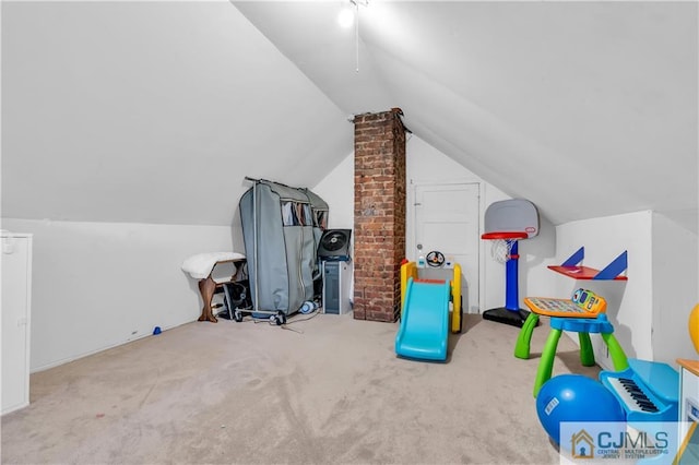 recreation room with lofted ceiling, brick wall, and carpet