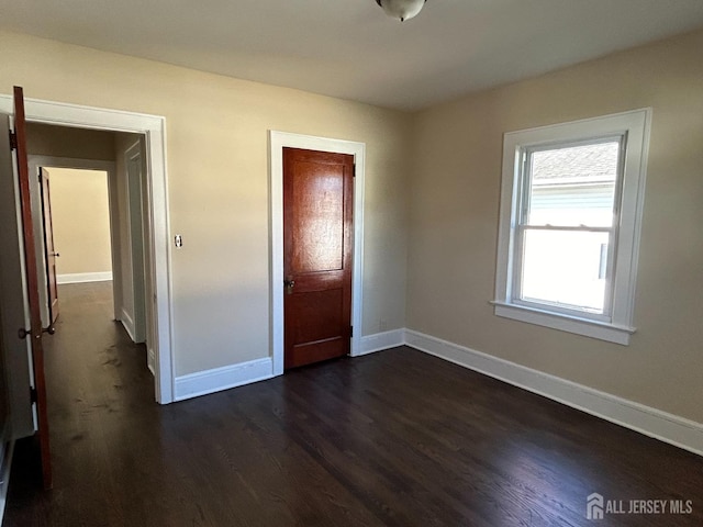 unfurnished bedroom with dark hardwood / wood-style flooring