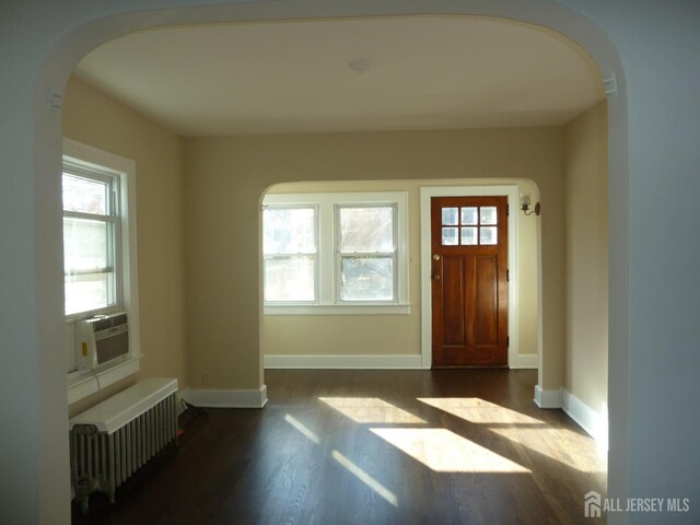 entrance foyer featuring cooling unit, dark hardwood / wood-style floors, and radiator