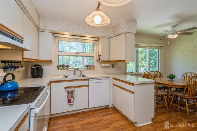 28 Thrush Dr, East Brunswick, NJ 08816 - kitchen with white appliances, a sink, a peninsula, light countertops, and wallpapered walls