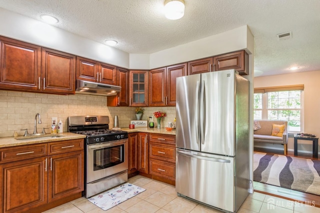 217 Nebula Rd, Piscataway, NJ 08854 - kitchen featuring stainless steel appliances, under cabinet range hood, a sink, a textured ceiling, and decorative backsplash