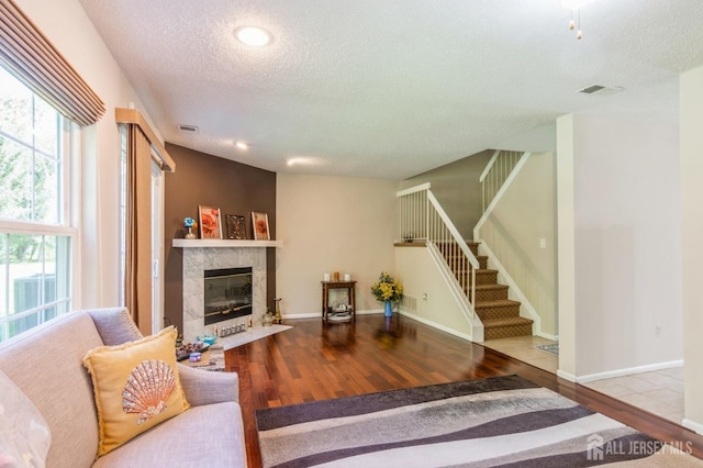 217 Nebula Rd, Piscataway, NJ 08854 - living room with a textured ceiling, wood finished floors, stairs, a tile fireplace, and baseboards