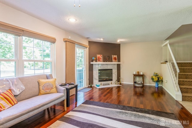 217 Nebula Rd, Piscataway, NJ 08854 - living area with wood finished floors, a textured ceiling, stairs, recessed lighting, and a tiled fireplace