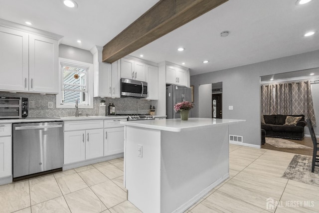 243 Donald Ave, Rahway, NJ 07065 - kitchen with appliances with stainless steel finishes, a sink, backsplash, light countertops, and white cabinetry